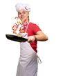 portrait of young cook man cooking vegetables on pan over white