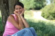 portrait of woman posing in park with face in her hands