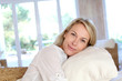 Portrait of blond mature woman relaxing in sofa