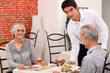 Waiter serving a senior couple