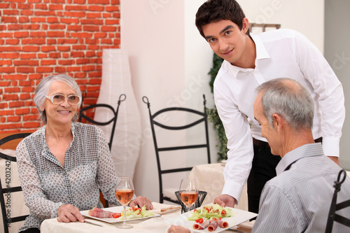 Photo: Waiter serving a senior couple Waiter serving a senior couple
