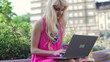 Attractive woman working on laptop in the city, steadicam shot