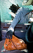 Ein Dieb entwendet eine Handtasche aus Auto