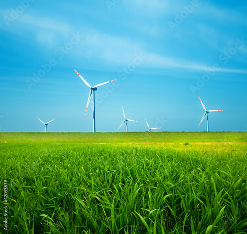 Photo: Wind turbines on green field. Clean energy Wind turbines on green field. Clean energy