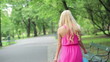 Happy woman with shoping bags walking in park, steadicam shot