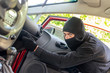 Photo: Thief in the mask breaks the door in the car Thief in the mask breaks the door in the car