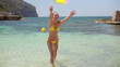 Girl playing with a beach ball on the shore, slow motion