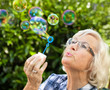 Seniorin macht Seifenblasen