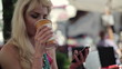 Woman using smartphone and drinking coffee in cafe