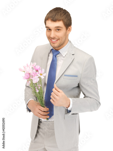 Photo: handsome man with flowers in hand handsome man with flowers in hand