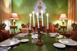 candlestick with five candles at glass table with serving, lamps