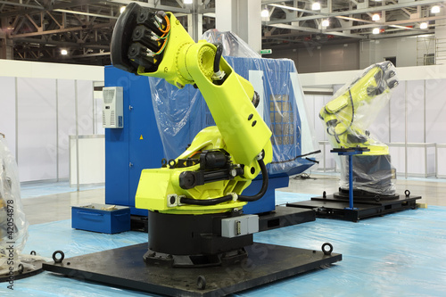Foto: two big new yellow robots for automotive industry at exhibition two big new yellow robots for automotive industry at exhibition