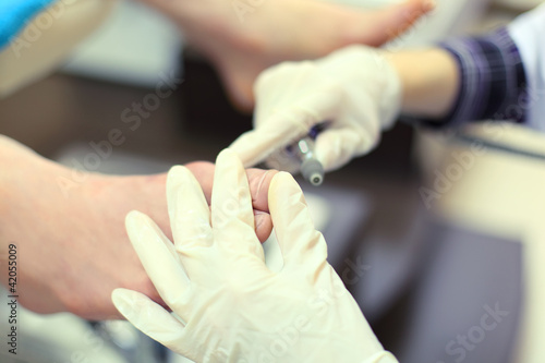 Photo: Woman hands wearing gloves practicing chiropody Woman hands wearing gloves practicing chiropody