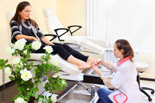Photo: Woman wearing white coat practices chiropody taking care of feet Woman wearing white coat practices chiropody taking care of feet