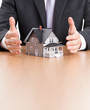 Foto: Businessman hands around house architectural model Businessman hands around house architectural model