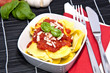 Tortellini with blurred ingredients in the background