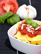 Tortellini with blurred ingredients in the background