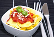 Tortellini in a bowl on black background