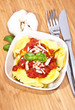 Tortellini with ingredients on wood