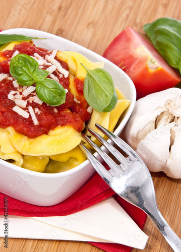 Photo: Fresh Tortellini in a bowl on wooden background Fresh Tortellini in a bowl on wooden background