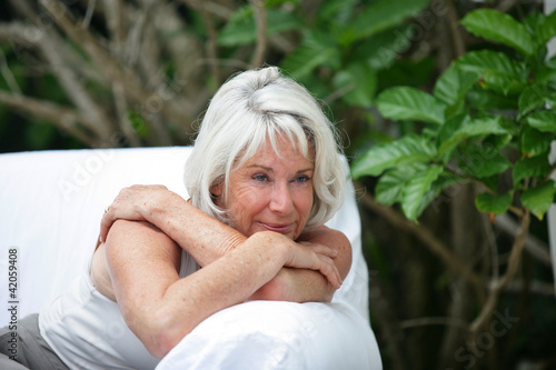 Foto: Old lady on sofa in the garden Old lady on sofa in the garden