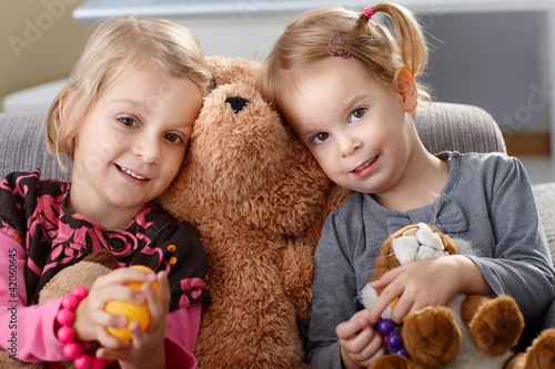 Foto: Little girls huddling up against teddy bear Little girls huddling up against teddy bear