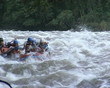 People in rubber boat ride wildwater river. Risky recreation