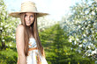 beautiful young woman standing near the apple tree on a warm sum