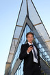 Young man with cellphone in front of a modern building