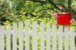 Foto: Briefkasten in rot am Zaun Briefkasten in rot am Zaun