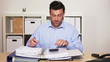 Happy business man working in office holding his thumb up