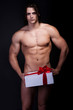 Photo: handsome muscular young man holding a present handsome muscular young man holding a present