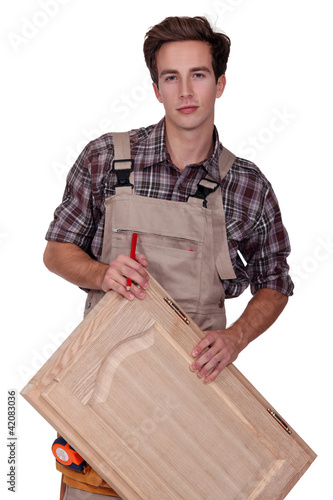 Foto: Carpenter holding cupboard door Carpenter holding cupboard door
