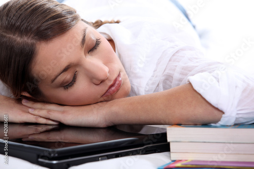 Photo: young woman sleeping on her computer young woman sleeping on her computer