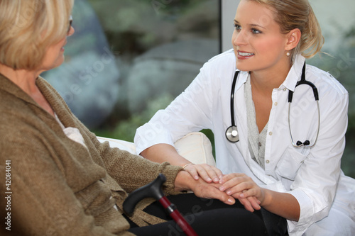 Foto: medical assistant taking care of senior woman medical assistant taking care of senior woman