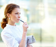Portrait of young beautiful business woman with newspaper