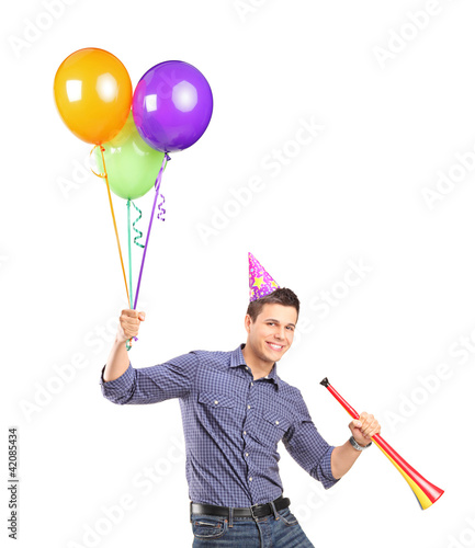 Foto: Portrait of a happy male holding balloons and a horn Portrait of a happy male holding balloons and a horn