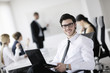 handsome young business man with colleagues in background