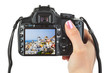 Foto: Camera in hand and Santorini (Greece) view Camera in hand and Santorini (Greece) view