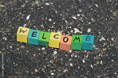Photo: The word Welcome - written on wood cubes, at the beach The word Welcome - written on wood cubes, at the beach