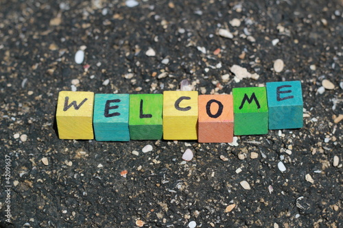 Photo: The word Welcome - written on wood cubes, at the beach The word Welcome - written on wood cubes, at the beach