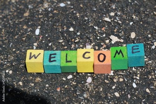 Photo: The word Welcome - written on wood cubes, at the beach The word Welcome - written on wood cubes, at the beach