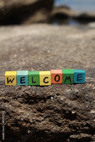 Photo: The word Welcome - written on wood cubes, at the beach The word Welcome - written on wood cubes, at the beach