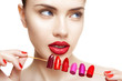 Beautiful woman makes choice between colors of lipstick