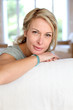 Beautiful blond mature woman relaxing in sofa