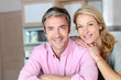 Cheerful couple leaning on kitchen counter
