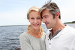 Couple embracing each other on a bridge by a lake