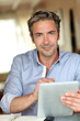 Handsome guy working from home with electronic tablet