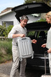 Couple putting suitcases in car trunk for a journey
