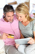 Couple sitting in sofa at home and doing online shopping